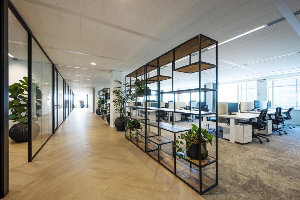 Moderne kantoorruimte aan de Thomas R. Malthusstraat met open werkplekken, glazen vergaderruimtes en planten.